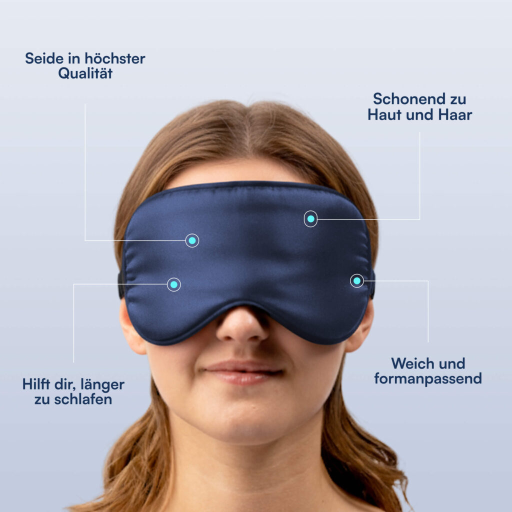 Person mit dunkelblauer Seidenschlafmaske, Haaransatz sichtbar, Gesicht bis zum Hals gezeigt