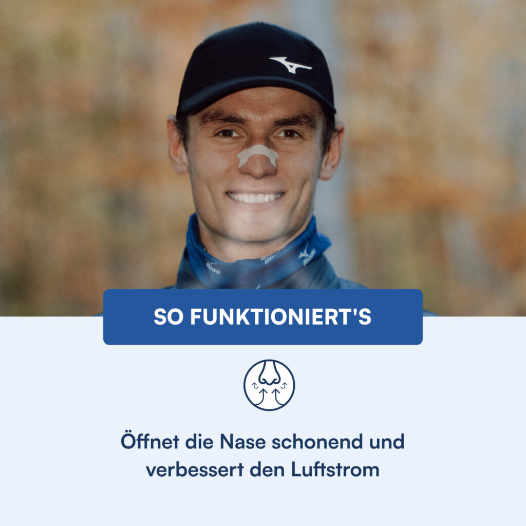 Junger Mann mit schwarzer Kappe und weißem Nasenpflaster lächelt, trägt blaues Halstuch