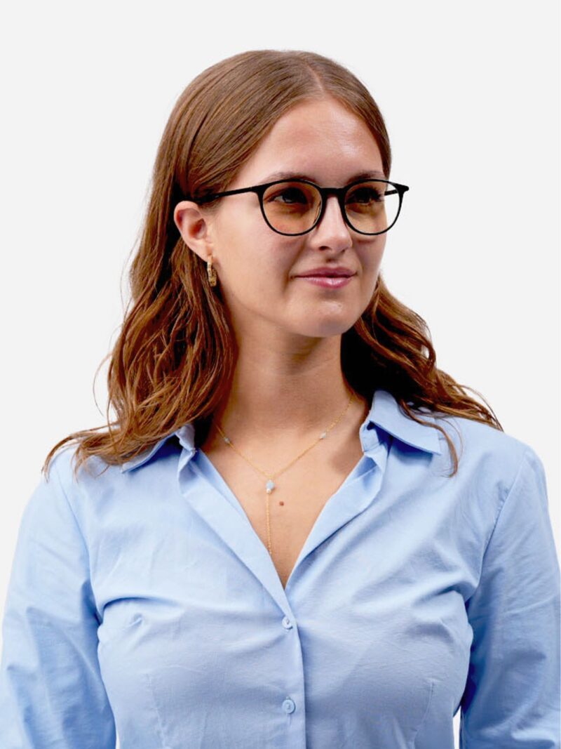 Frau mit schwarzer Brille, langem hellbraunem Haar, hellblauem Hemd und feiner Goldkette, leicht lächelnd